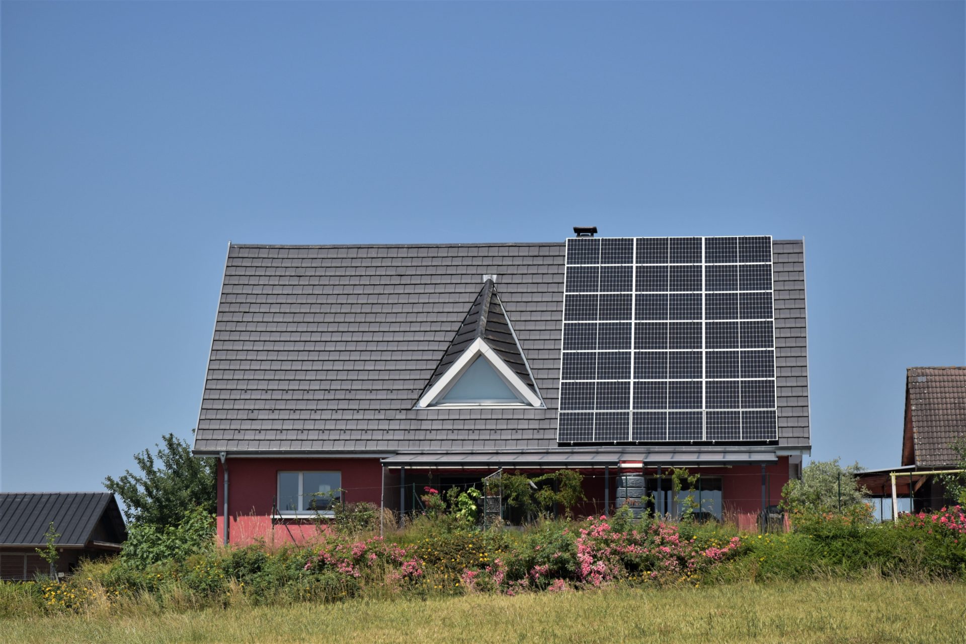 La mitad del tejado inclinado de una casa unifamiliar está cubierta con paneles solares.